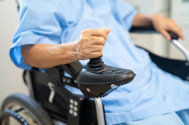 Asian senior woman patient on electric wheelchair with remote control at hospital, healthy strong medical concept.