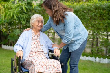 Bakıcı yardım ve bakım Asyalı yaşlı kadın hasta hemşire hastanesi koğuşunda tekerlekli sandalyede oturuyor, sağlıklı ve güçlü..