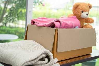 Dünyada fakir insanlara yardım etmek için evde kullanılmış giysiler ve oyuncak bebeklerle dolu bir bağış kutusu..