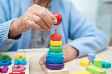 Alzheimer Hastalığı AD, bunama geçiren Asyalı yaşlı kadın hasta pratik motor beceri rehabilitasyonu öğreniyor.