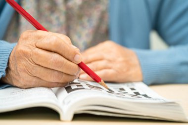Alzheimer hastalığı AD, bunama için sudoku bulmacası oynayan Asyalı yaşlı kadın.