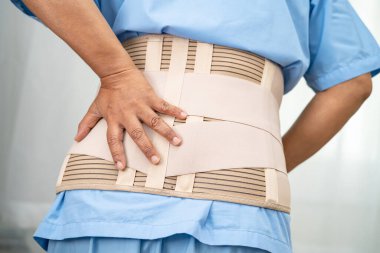 Ortopedik bel kemiği için sırt ağrısı destek kemeri takan Asyalı bir hasta..