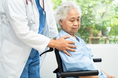 Doktor yardımı ve bakımı, hastanede tekerlekli sandalyedeki Asyalı yaşlı kadın..