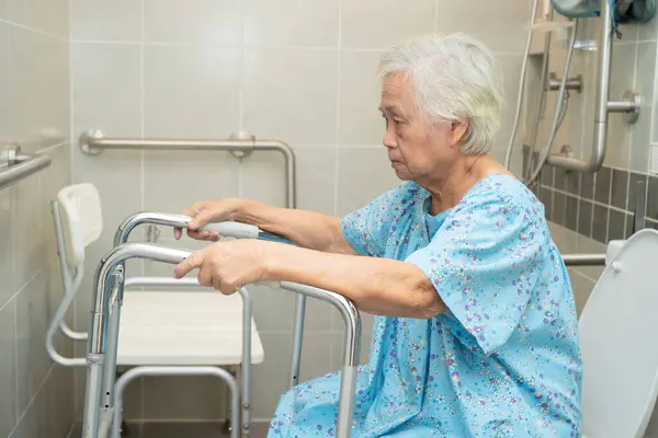 stock image Asian elderly woman patient use toilet bathroom handle security in nursing hospital, healthy strong medical concept.