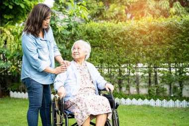 Bakıcı yardım ve bakım Asyalı yaşlı kadın hasta hemşire hastanesi koğuşunda tekerlekli sandalyede oturuyor, sağlıklı ve güçlü..