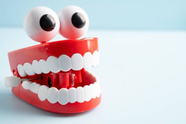Diş komik oyuncak takma diş kırmızı çene ve beyaz arkaplan üzerinde göz kopyalama alanı ile.