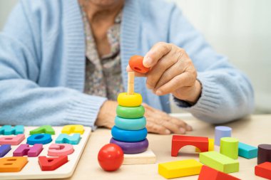 Alzheimer Hastalığı AD, bunama geçiren Asyalı yaşlı kadın hasta pratik motor beceri rehabilitasyonu öğreniyor.