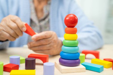 Alzheimer Hastalığı AD, bunama geçiren Asyalı yaşlı kadın hasta pratik motor beceri rehabilitasyonu öğreniyor.