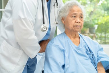 Doktor yardımı ve bakımı, hastanede tekerlekli sandalyedeki Asyalı yaşlı kadın..