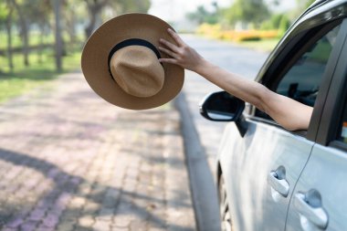 Yaz tatilinde el kaldırarak ve arabanın önünde şapka tutarak seyahat etmenin keyfini çıkarın..