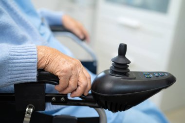 Asian senior woman patient on electric wheelchair with remote control at hospital, healthy strong medical concept.