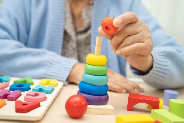 Alzheimer Hastalığı AD, bunama geçiren Asyalı yaşlı kadın hasta pratik motor beceri rehabilitasyonu öğreniyor.