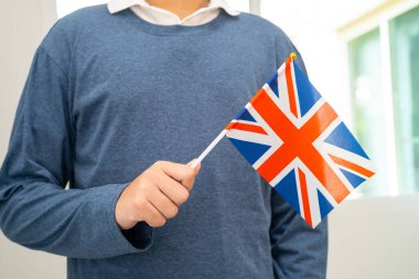 İngilizce öğren, Asyalı ergen öğrenci okulda İngiliz bayrağı taşıyor..