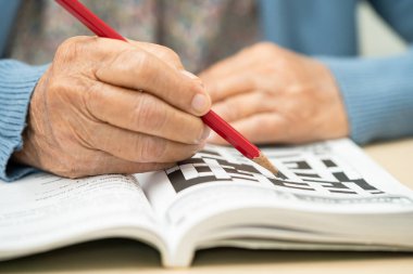 Alzheimer hastalığı AD, bunama için sudoku bulmacası oynayan Asyalı yaşlı kadın.