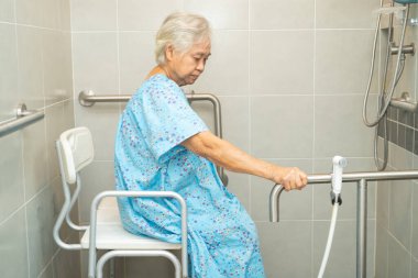 Asyalı yaşlı kadın hasta, hemşire hastanesinde tuvalet temizliği yapıyor. Sağlıklı ve güçlü bir tıbbi konsept..