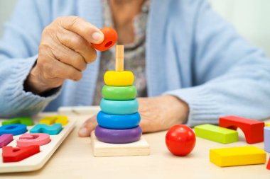 Alzheimer Hastalığı AD, bunama geçiren Asyalı yaşlı kadın hasta pratik motor beceri rehabilitasyonu öğreniyor.