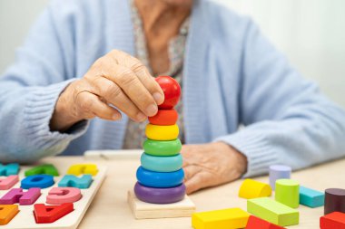 Alzheimer Hastalığı AD, bunama geçiren Asyalı yaşlı kadın hasta pratik motor beceri rehabilitasyonu öğreniyor.