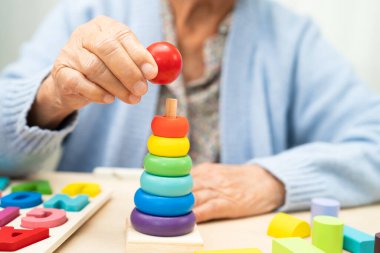 Alzheimer Hastalığı AD, bunama geçiren Asyalı yaşlı kadın hasta pratik motor beceri rehabilitasyonu öğreniyor.