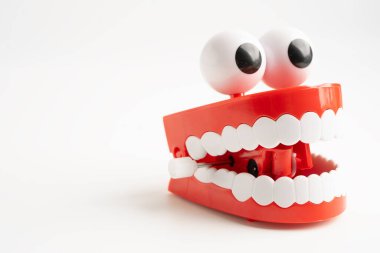 Diş komik oyuncak takma diş kırmızı çene ve beyaz arkaplan üzerinde göz kopyalama alanı ile.