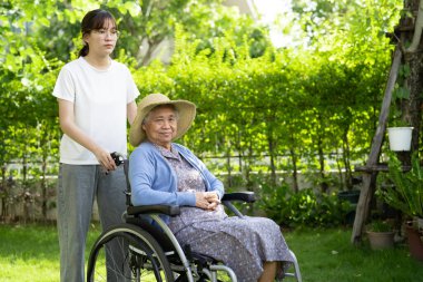 Bakıcı yardım ve bakım Asyalı yaşlı kadın hasta hemşire hastanesi koğuşunda tekerlekli sandalyede oturuyor, sağlıklı ve güçlü..