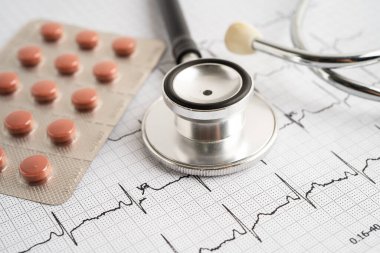 Elektrokardiyogramda stetoskop. Kapsül ilacı, kalp dalgası, kalp krizi, kardiyogram raporu..