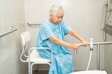 Asyalı yaşlı kadın hasta, hemşire hastanesinde tuvalet temizliği yapıyor. Sağlıklı ve güçlü bir tıbbi konsept..