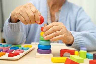 Alzheimer Hastalığı AD, bunama geçiren Asyalı yaşlı kadın hasta pratik motor beceri rehabilitasyonu öğreniyor.