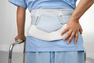 Ortopedik bel kemiği için sırt ağrısı destek kemeri takan Asyalı bir hasta..