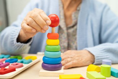 Alzheimer Hastalığı AD, bunama geçiren Asyalı yaşlı kadın hasta pratik motor beceri rehabilitasyonu öğreniyor.