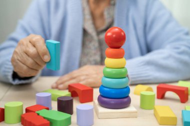 Alzheimer Hastalığı AD, bunama geçiren Asyalı yaşlı kadın hasta pratik motor beceri rehabilitasyonu öğreniyor.