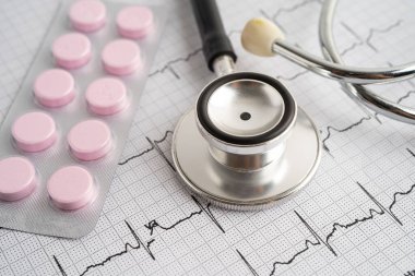 Elektrokardiyogramda stetoskop. Kapsül ilacı, kalp dalgası, kalp krizi, kardiyogram raporu..
