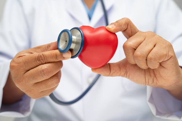 Doctor holding a red heart in hospital ward, healthy strong medical.
