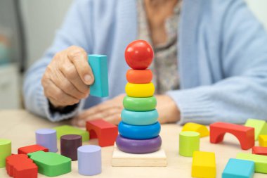 Alzheimer Hastalığı AD, bunama geçiren Asyalı yaşlı kadın hasta pratik motor beceri rehabilitasyonu öğreniyor.