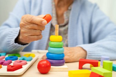 Alzheimer Hastalığı AD, bunama geçiren Asyalı yaşlı kadın hasta pratik motor beceri rehabilitasyonu öğreniyor.