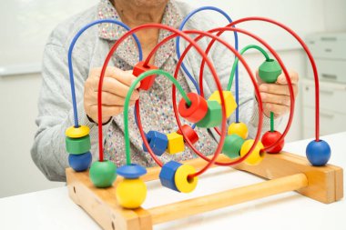 Asyalı yaşlı bir kadın, geliştirme oyunu oynuyor..