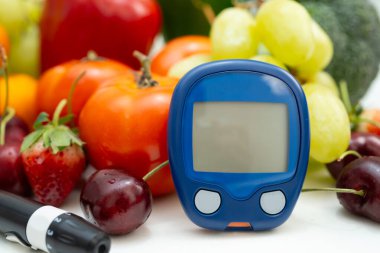 Asya 'da el ele tutuşan dijital glikoz monitörü sebze ve meyveli sağlıklı gıda ölçümü.