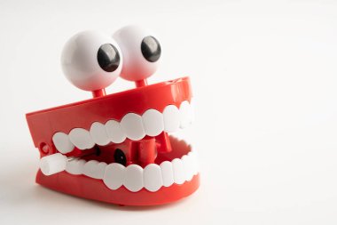 Diş komik oyuncak takma diş kırmızı çene ve beyaz arkaplan üzerinde göz kopyalama alanı ile.