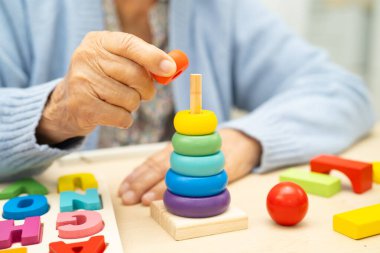 Alzheimer Hastalığı AD, bunama geçiren Asyalı yaşlı kadın hasta pratik motor beceri rehabilitasyonu öğreniyor.