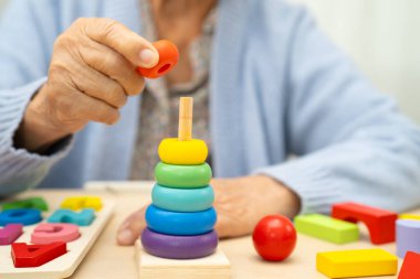 Alzheimer Hastalığı AD, bunama geçiren Asyalı yaşlı kadın hasta pratik motor beceri rehabilitasyonu öğreniyor.