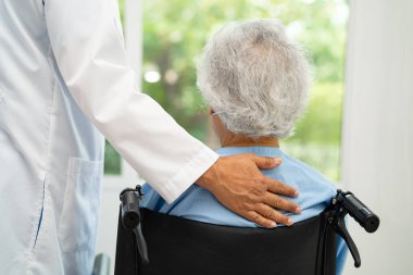 Doktor yardımı ve bakımı, hastanede tekerlekli sandalyedeki Asyalı yaşlı kadın..