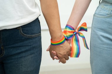 Gökkuşağı bilekliği takan Asyalı LGBT çifti..