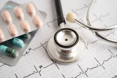 Elektrokardiyogramda stetoskop. Kapsül ilacı, kalp dalgası, kalp krizi, kardiyogram raporu..