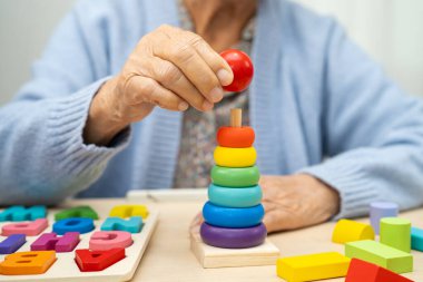 Alzheimer Hastalığı AD, bunama geçiren Asyalı yaşlı kadın hasta pratik motor beceri rehabilitasyonu öğreniyor.