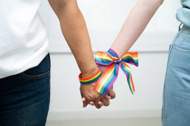Gökkuşağı bilekliği takan Asyalı LGBT çifti..