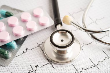 Elektrokardiyogramda stetoskop. Kapsül ilacı, kalp dalgası, kalp krizi, kardiyogram raporu..