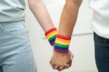 Gökkuşağı bilekliği takan Asyalı LGBT çifti..