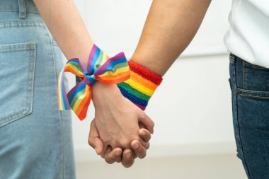 Gökkuşağı bilekliği takan Asyalı LGBT çifti..