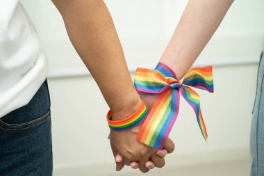 Gökkuşağı bilekliği takan Asyalı LGBT çifti..