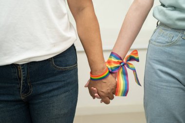 Gökkuşağı bilekliği takan Asyalı LGBT çifti..