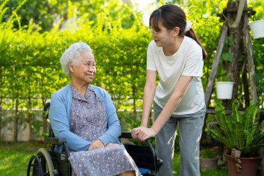 Bakıcı yardım ve bakım Asyalı yaşlı kadın hasta hemşire hastanesi koğuşunda tekerlekli sandalyede oturuyor, sağlıklı ve güçlü..